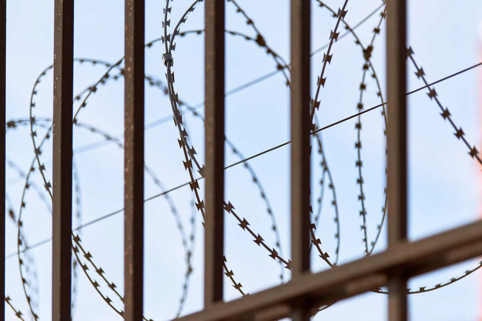 Cerca de alambre de púas en un centro de detención de ICE — persona con orden final de deportación en Miami busca opciones legales con HHA Law